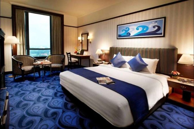 Une suite d'hôtel luxueuse aux tons bleus et blancs, offrant une atmosphère de chambre apaisante propice au repos.