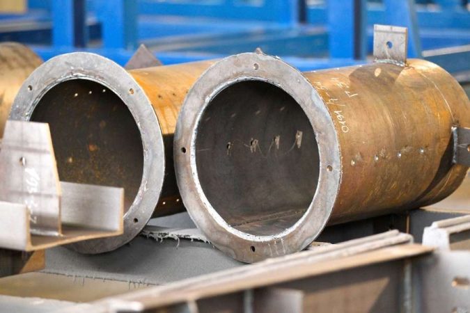 Gros plan sur l'extrémité d'un gros tuyau en acier usiné dans un atelier.